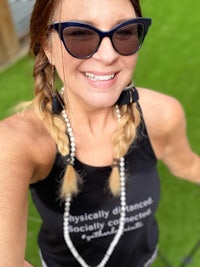 a woman wearing sunglasses and a tank top taking a selfie