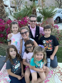 a family posing for a picture in front of a palm tree