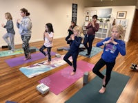 a group of children practicing yoga in a room