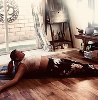 a woman laying on a yoga mat in front of a window