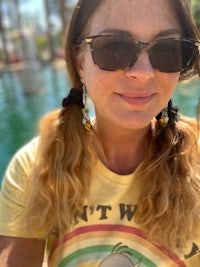 a woman wearing sunglasses and a yellow t - shirt