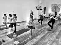 a black and white photo of a group of people practicing yoga