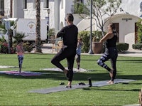 a group of people doing yoga in front of a building